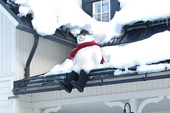 Photo shows a young daredevil snow man sitting at the edge of Villa Cone Beach roof.