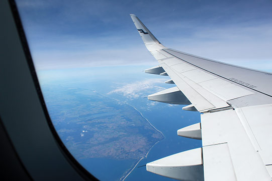 Photo shows a wing af an airplane possibly bringing guests to Villa Cone Beach.