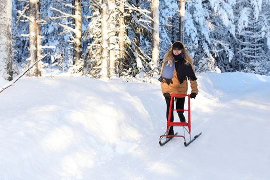 Photo shows a young woman kicksledding on a snowy Villa Cone Beach road.