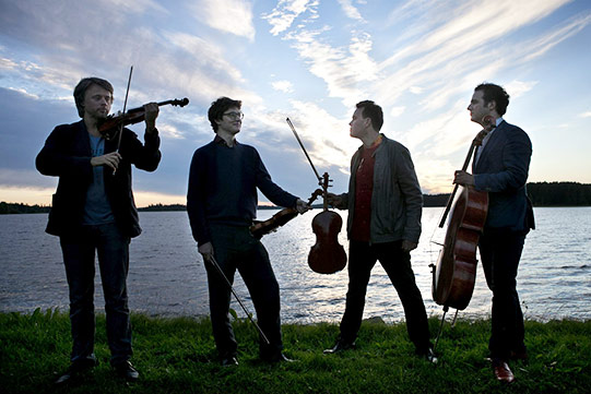 Photo shows world-famous Kuhmo Chamber Music festival musicians relaxing at a Kuhmo lakeside.